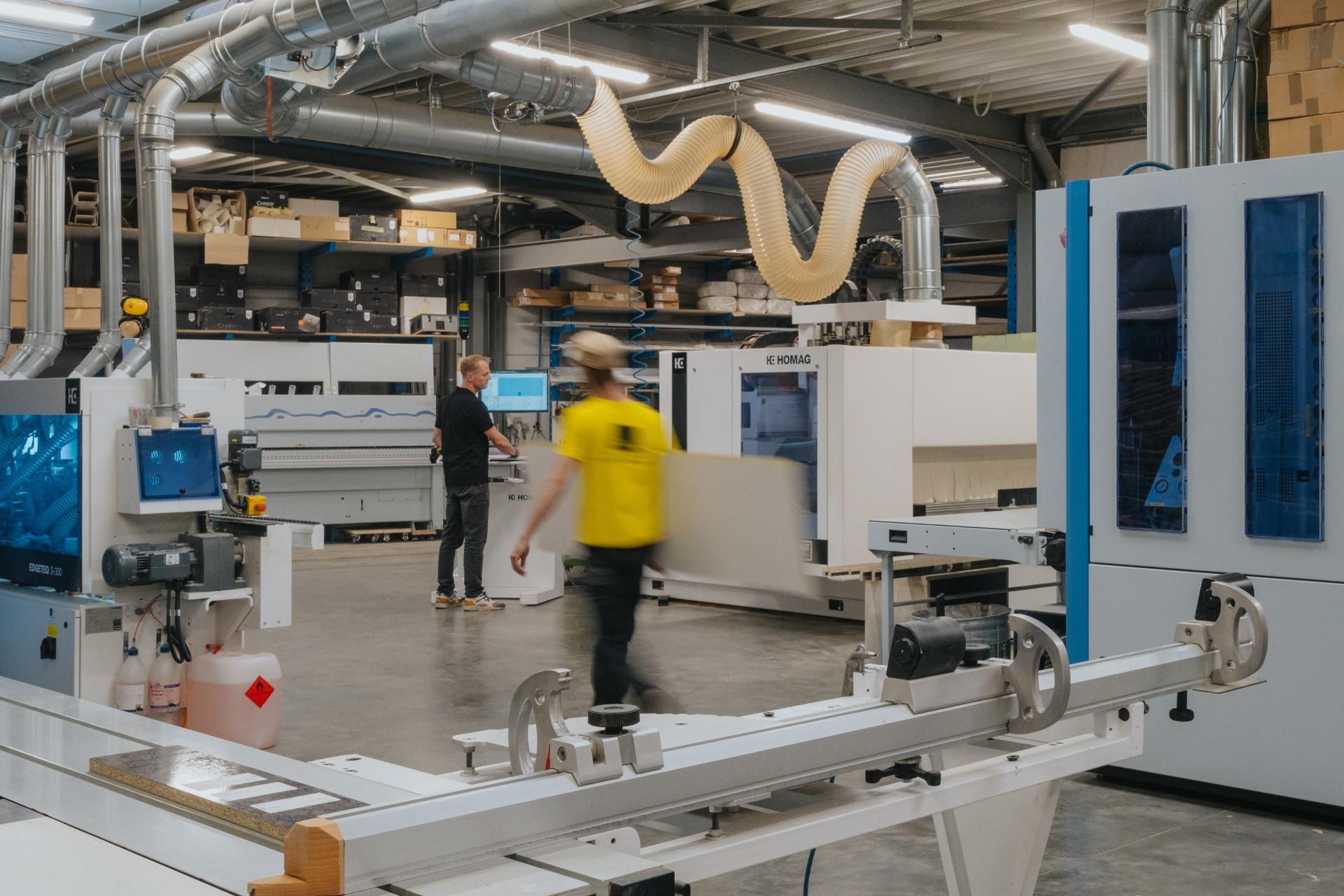 Een schrijnwerker werkt nauwkeurig aan maatmeubilair in een ambachtelijke werkplaats. Hoogwaardige materialen en precisie zorgen voor een perfecte afwerking van meubels op maat.