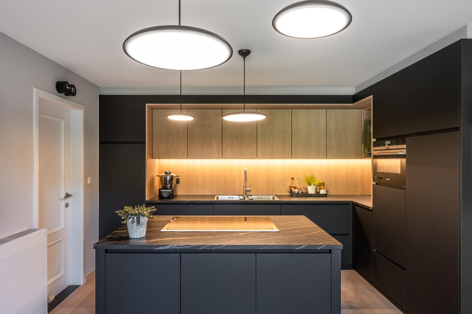 Moderne keuken op maat met zwarte kasten, houten accenten en functioneel keukeneiland door Dorus Coppelmans Vakmanschap