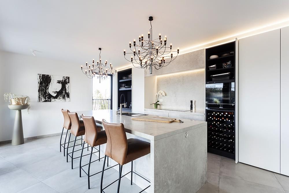 Luxueuze keuken met betonnen eiland, lederen barkrukken en wijnkast op maat door Dorus Coppelmans Totaalinterieur