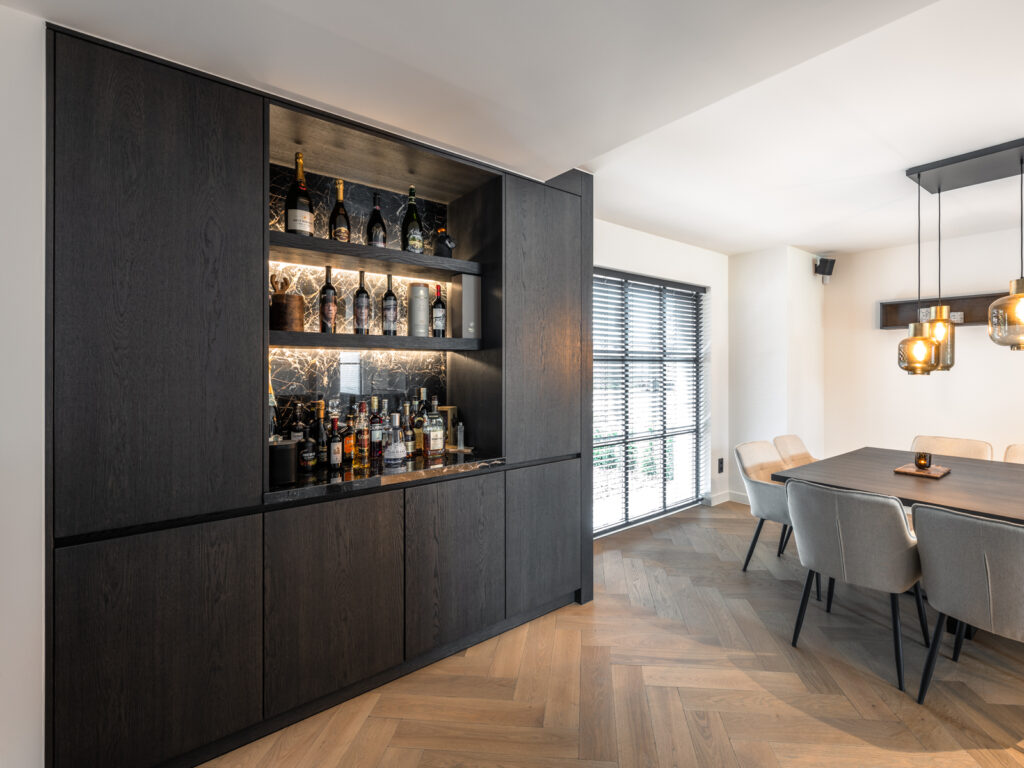 luxe keuken in donker hout met barkast